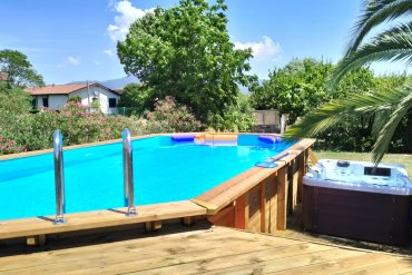 Piscina fuori terra in legno con solarium su più livelli e scala integrata. Un vero angolo benessere in giardino, con area relax, vasca idromassaggio e doccia esterna. Ideale per chi cerca comfort e stile all’aperto.