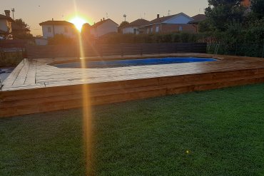 Scopri la piscina fuori terra White Pool 910x460x130 cm rifinita con un elegante deck in legno. Le immagini mostrano il prodotto finito perfettamente integrato nel giardino, con struttura in acciaio zincato, liner resistente e bordo in legno per un design su misura e un comfort senza paragoni.