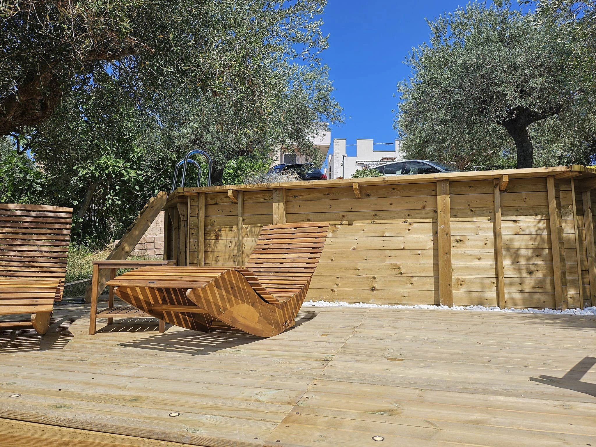 Piscine hors sol octogonale en bois avec vue panoramique sur la campagne et échelle en acier